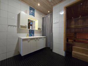 a kitchen with white cabinets and a sink and a mirror at Orava Järven Talo in Ranua +21 photos