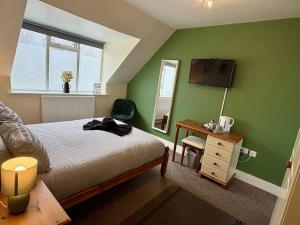 a bedroom with green walls and a bed and a mirror at Travellers Rest Motel in Ingoldmells +19 photos
