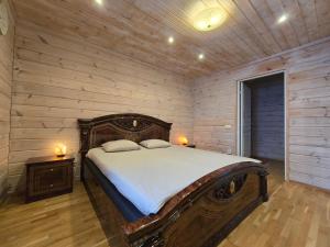 a bedroom with a large bed in a wooden wall at Orava Järven Talo in Ranua