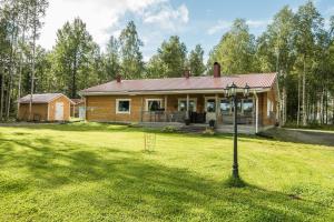 a log home with a porch on a grass field at Orava Järven Talo in Ranua