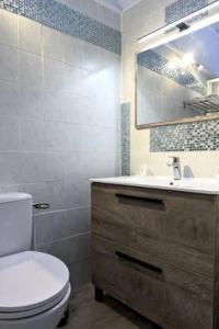 a bathroom with a white toilet and a sink at Hôtel Archipel in Balaruc-les-Bains