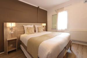a bedroom with a large bed and a window at Hôtel Archipel in Balaruc-les-Bains
