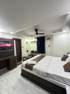 a bedroom with a large bed and a flat screen tv at Hotel Aman in Patna
