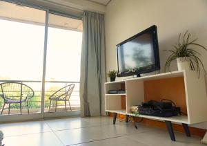 a living room with a television and a balcony at Zona shopping del Sol, Asunción in Asunción