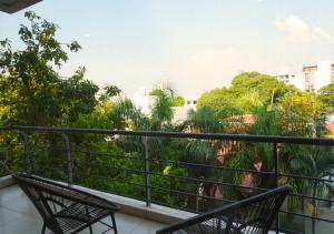a balcony with two chairs and trees at Zona shopping del Sol, Asunción in Asunción