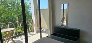 a bedroom with a view of a balcony with a chair at Casa Laud Cuarto Guamuchil in Guayabas