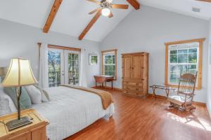a bedroom with a bed and a chair and windows at Fairlawn on the Blanco in Wimberley