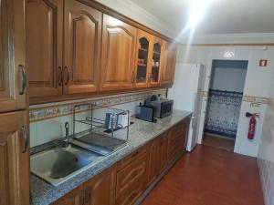 a kitchen with wooden cabinets and a sink at Mouraria in Elvas +6 photos