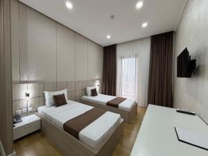 a hotel room with two beds and a television at ART REGENCY Premium Hotel in Tashkent