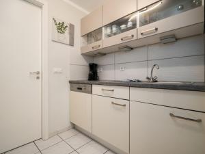 a kitchen with white cabinets and a sink at Seepferdchen am Müritzufer in Waren