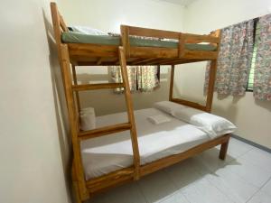 two bunk beds in a room with white sheets at Casa Fleur in Cangalwang