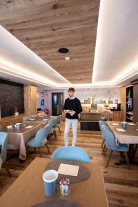a man standing in the middle of a restaurant at Negritella Sweet Hotel in Ziano di Fiemme