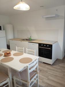 a kitchen with a table and a stove and a sink at Le gîte 1869 in Clarques
