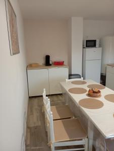 a kitchen with a table with chairs and a counter at Le gîte 1869 in Clarques +10 photos