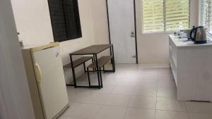 a kitchen with a table and a table and a refrigerator at Casa Fleur in Cangalwang
