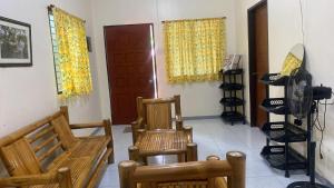 a room with two wooden chairs and a door at Casa Fleur in Cangalwang