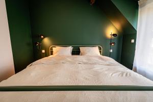 a bedroom with a bed with a green wall at Ferox Stay in Varsenare