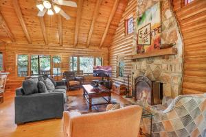 a living room with a stone fireplace in a log cabin at Falls Log Home in Wimberley