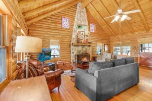 a living room with furniture and a fireplace in a log cabin at Falls Log Home in Wimberley