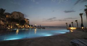 a large swimming pool at a resort at night at Samarah EP 04 full Sea View and poll access prime location with big terrace, in Sowayma +49 photos
