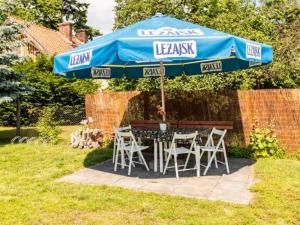 a table and chairs under an umbrella in a yard at Spełniony sen in Stegna