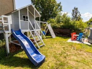 a playground with a slide next to a house at Spełniony sen in Stegna