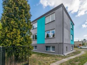 a gray building with a blue stripe on it at Spełniony sen in Stegna
