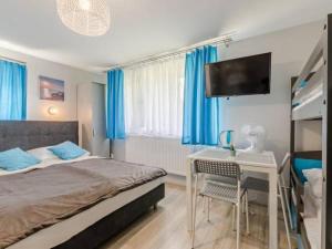 a bedroom with a bed and a desk and a tv at Spełniony sen in Stegna +5 photos