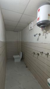 a bathroom with a toilet and a light on the wall at Himalaya View Resort in Barkot