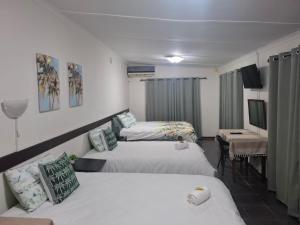 una camera d'albergo con due letti e una televisione di Bright Diamond Inn a Kimberley