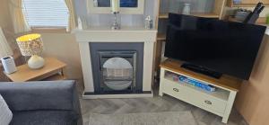 a living room with a tv and a fireplace at Pcj caravan hire in Kinmel Bay