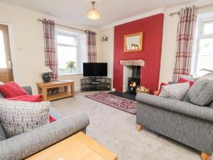 a living room with two couches and a fire place at Yewbarrow in Seascale