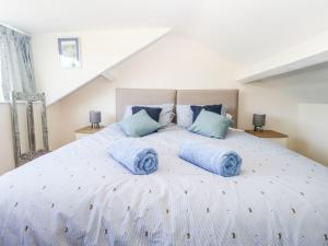 a bedroom with a large bed with blue pillows on it at Yewbarrow in Seascale