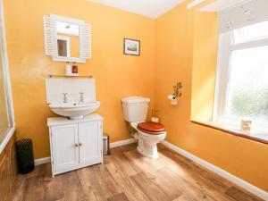 a bathroom with a toilet and a sink and a window at Yewbarrow in Seascale +25 photos