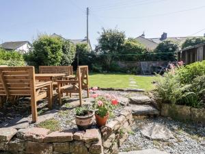 a garden with a wooden table and chairs and flowers at Yewbarrow in Seascale