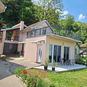 a house with a balcony and a patio at Apartmani Đorđević in Golubac