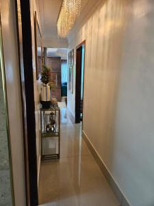 a hallway with a table and a wall with a light at Corpo Arte Acomodação in Goiânia
