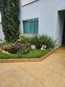 a garden with flowers in front of a building at Corpo Arte Acomodação in Goiânia