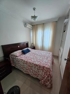 a bedroom with a bed with a red blanket at Corpo Arte Acomodação in Goiânia