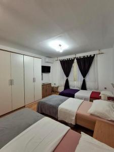 a bedroom with two beds and a television in it at IN Kala in Rijeka