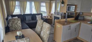 a kitchen and living room with a couch and a table at Pcj caravan hire in Kinmel Bay