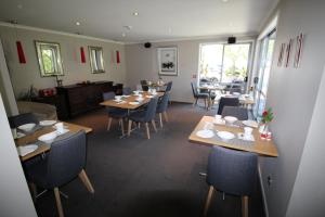 a dining room with wooden tables and chairs at Chalet Queenstown in Queenstown