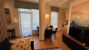 a living room with a table and a living room with a television at DO Apartments in Druskininkai