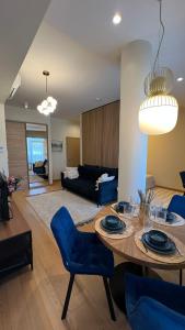 a living room with a table and blue chairs at DO Apartments in Druskininkai