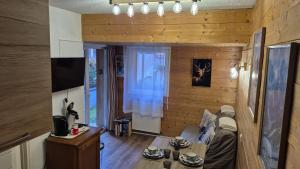 a living room with wooden walls and a couch and a television at Douce Altitudes Cauterets in Cauterets
