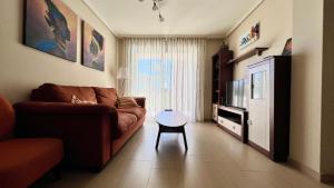 a living room with a couch and a television at 2-bedroom apartment with terrace VistaRoja in Granadilla de Abona