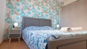 a bedroom with a bed with blue and orange wallpaper at Les Cannes Trankil in Saint-Louis +15 photos