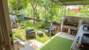 a patio with two chairs and a grill at Les Cannes Trankil in Saint-Louis