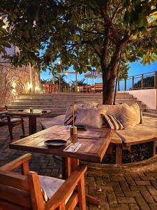 a wooden table with a couch under a tree at Amerigo Vespucci Mar e Ceu in Morro de São Paulo
