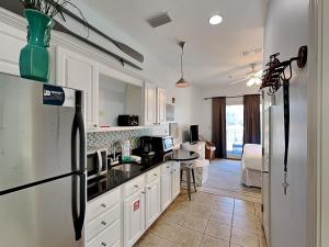 a kitchen with white cabinets and a refrigerator at Inn at Seacrest #206 in Rosemary Beach